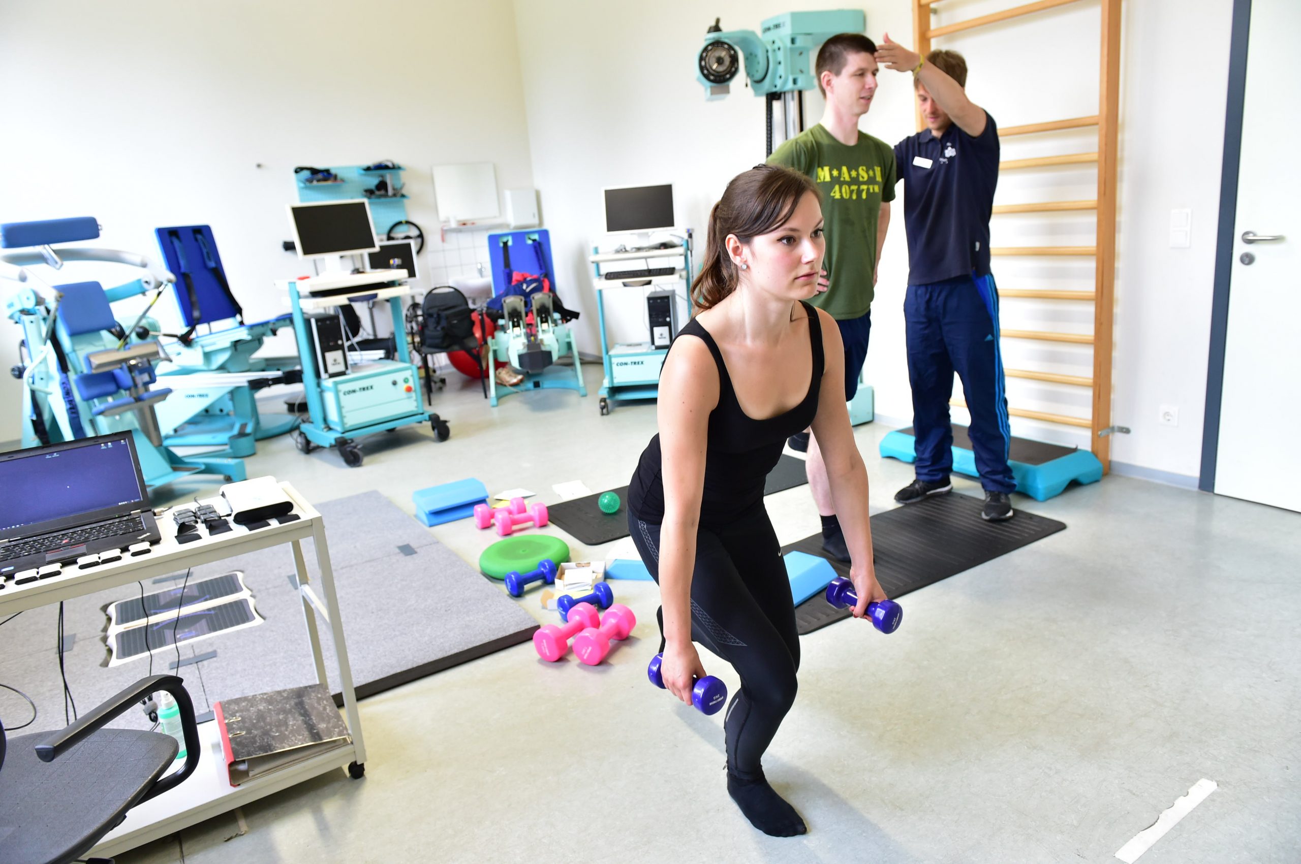 Probanden machen unter Anleitung Übungen in einem Trainings- und Untersuchungsraum.